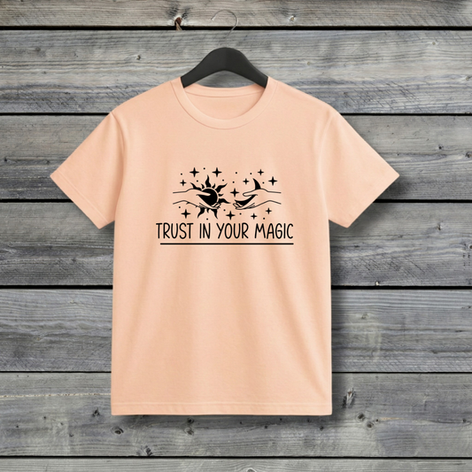 Peech t-shirt with 'Trust in Your Magic' text and graphic on a wooden background