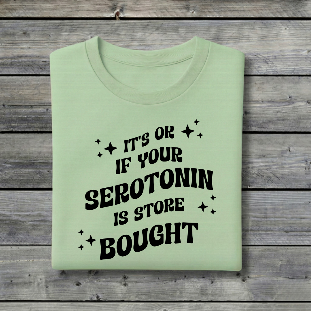 Light green t-shirt with black text on a wooden background