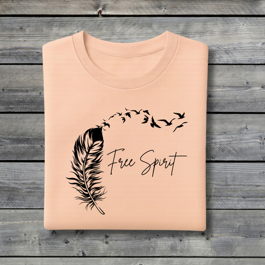 Peach sweatshirt with black feather and 'Free Spirit' text on a wooden background